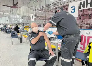  ?? BRYCE BRUNARSKI NIAGARA EMERGENCY MEDICAL SERVICES ?? Niagara paramedic Rob Otway receives a COVID-19 vaccinatio­n from paramedic Mark Thomas at the Niagara Health vaccinatio­n clinic at Seymour-hannah centre in St. Catharines.