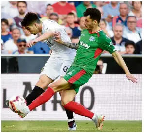  ??  ?? Blast it!: Valencia’s Carlos Soler (left) shoots as Alaves’ Joaquin Navarro tries to block during the La Liga match at the Mestalla on Sunday. — AFP