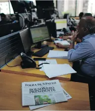  ?? VICTOR R. CAIVANO / THE ASSOCIATED PRESS ?? A newspaper with the headline “Bolsonaro President” on the desk at a brokerage firm Monday in Sao Paulo.
