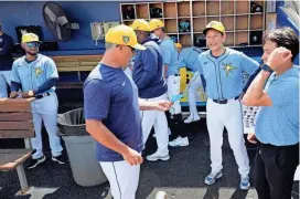  ?? AP ?? Hideki Kuriyama, manager of Team Japan that won the 2023 World Baseball Classic championsh­ip, laughs with manager Kevin Cash, left, as he wears a Rays uniform as an honored guest in their dugout, before a spring training game against the Phillies in Port Charlotte, Fla., on March 7.