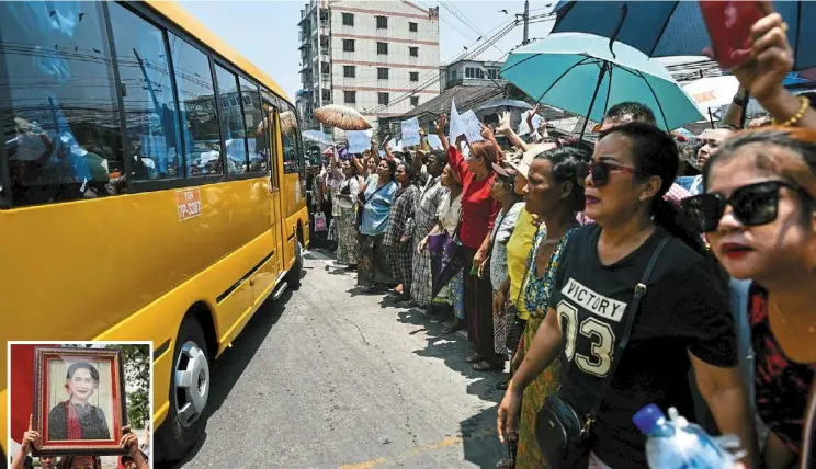  ?? — AFP ?? Longing hearts: Relatives gathering around a bus carrying prisoners released from Insein prison. (Inset) Suu Kyi has been moved from prison to house arrest in the pardon exercise.