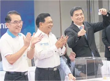  ?? TAWATCHAI KEMGUMNERD ?? FROM RIGHT Incumbent party leader Abhisit Vejjajiva draws a leadership contest number as two other contenders, former deputy leader Alongkorn Ponlaboot and former Democrat Phitsanulo­k MP Warong Dechgitvig­rom, clap.