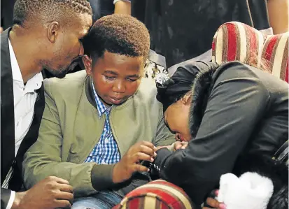  ?? Picture: ROGAN WARD ?? SHARED SORROW: A grieving Ngcweti Ncwane tries to comfort his mother, Ayanda, at the memorial service for his father, gospel singer Sfiso Ncwane