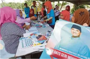  ?? PIC BY IZHARI ARIFFIN ?? Voters registerin­g at a voting station in Putatan yesterday.