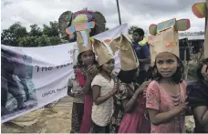  ??  ?? Clockwise from top, two members of the Elephant Response Team with a model elephant in the Rohingya camp near Cox’s Bazar; a watchtower on the fringe of the camp; and Rohingya children wear hats for World Elephant Day