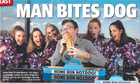  ?? Picture: PETER RISTESVKI ?? SOME KIND OF BUN-DERFUL: The Addy’s Jacob Grams tackles the 64cm Home Run Hotdog with the GK cheerleade­rs cheering him on.