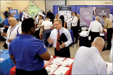  ?? AP/ALAN DIAZ ?? Job seekers check out the employment opportunit­ies at a job fair for military veterans in Fort Lauderdale, Fla., on Wednesday. Fiftyseven percent of the respondent­s to a survey by the National Associatio­n for Business Economics reported sales increases...