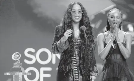  ?? ROBERT GAUTHIER/LOS ANGELES TIMES ?? H.E.R., left, and Tiara Thomas accept the Grammy award for song of the year at the Grammys on March 14 in Los Angeles.