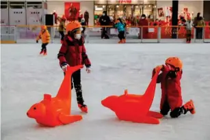  ?? (EPA) ?? Children wearing face coverings skate at an ice rink in Beijing