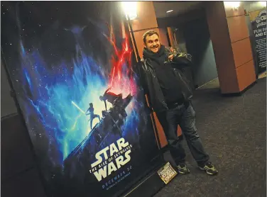  ??  ?? ABOVE: Star Wars fan Nicholas Simonini, of North Providence, has his picture taken near the new promotiona­l poster for ‘Star Wars: The Rise of Skywalker’ at Cinemaworl­d in the Lincoln Mall Friday. He arrived early to be first in line for the
7:45 p.m. show.