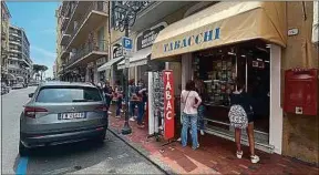  ??  ?? Une file d’attente, mercredi, devant un tabac de Vintimille (Italie).