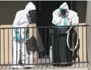  ?? Joe Raedle / Getty Images ?? A hazardous material crew sanitizes the apartment of an Ebola patient admitted to a hospital in Dallas.