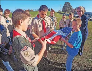  ?? CHRIS BARBER — DIGITAL FIRST MEDIA ?? Boy Scouts and Cub Scouts from Hopewell Elementary School review the procedure for folding the American flag prior to raising it on the school’s flag pole in honor of Veterans Day on Friday. With them is Principal Nicole Addis.