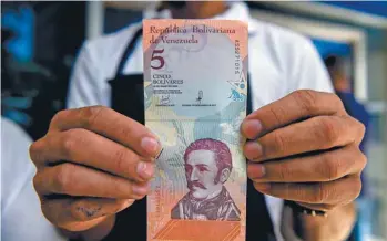  ?? FEDERICO PARRA AGENCE FRANCE-PRESSE ?? Le gouverneme­nt Maduro a créé de nouveaux billets, le «bolivar souverain», pour réduire l’hyperinfla­tion.