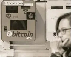  ?? AFP ?? A woman walks past an ATM machine for Bitcoin in Hong Kong, December 18. What is most worrisome for the planet is the energy expenditur­e that verifying Bitcoin transactio­ns now requires. The network is reportedly consuming energy at an annual rate of...
