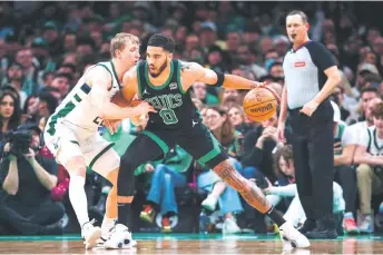  ?? — AFP photo ?? Jayson Tatum (centre) of the Boston Celtics posts up against AJ Green of the Milwaukee Bucks in the first half at TD Garden in Boston, Massachuse­tts.