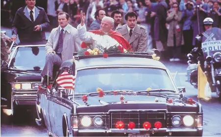  ?? AP FILE PHOTO ?? PROUD DAY FOR BOSTON: Pope John Paul II greets the crowd from the rooftop of the motorcade carrying him through the streets of Boston on Oct. 1, 1979.