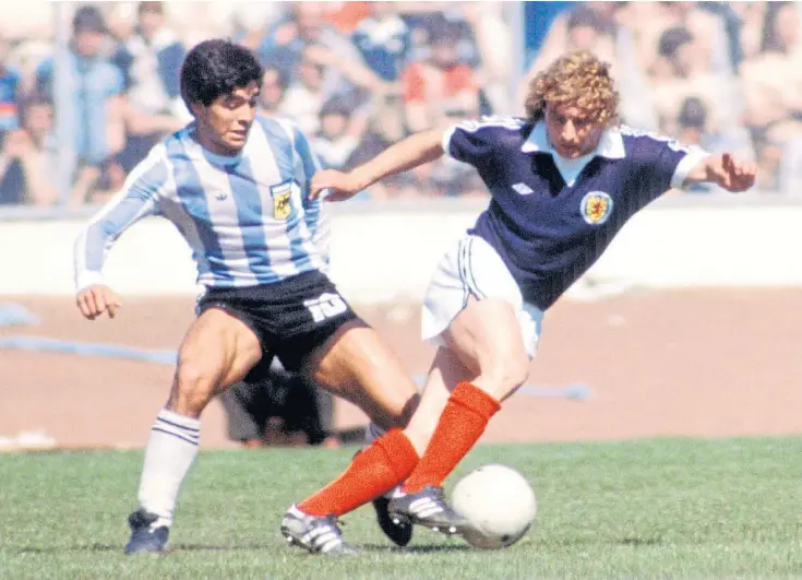  ??  ?? Diego Maradona puts in a challenge on Scotland’s Asa Hartford in the 1979 meeting at Hampden that Argentina won 3-1.