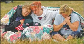  ?? (File Photo/ap/julie Jacobson) ?? Shannon Barry (from left), Lisa Starr and Michelle Wagner, all of Hershey, Pa., comfort each other in September 2002 as they listen to a memorial service for victims of Flight 93 near Shanksvill­e, Pa. President George W. Bush laid a wreath at the crash site later in the day to mark the anniversar­y of the terrorist attacks.