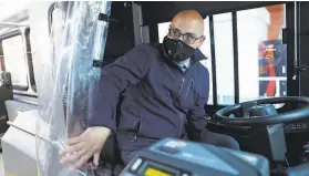  ?? Scott Strazzante / The Chronicle ?? Golden Gate Transit driver Luis Licea works behind a plastic barrier, one of the new safety measures on the agency’s bus lines.