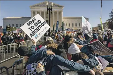  ?? Andrew Harnik Associated Press ?? ABORTION OPPONENTS pray in front of the U.S. Supreme Court building in Washington as the court’s nine justices hear arguments about a Mississipp­i law that bans abortions after 15 weeks of pregnancy.