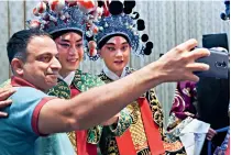  ?? ?? A participan­t at the 2023 Beijing Internatio­nal Media Forum takes a selfie with actors of the Kunqu opera in Beijing on 13 October