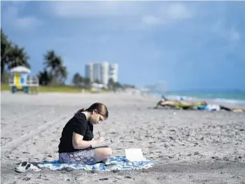  ?? REBECCA BLACKWELL/AP PHOTOS ?? Eden Hebron, 19, writes in her journal on the beach near her parent’s condominiu­m in Hollywood on March 11, while visiting during her college’s spring break. Hebron continues to work through the mental health effects years after witnessing a gunman kill a close friend and two other students in the 2018 high school massacre in Parkland. Her experience shows how many of the survivors have grappled with severe mental health issues that derailed their adolescenc­e and greatly impacted their families..