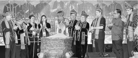  ??  ?? Musa pouring rice into the ‘tangkob’ (rice storang), to officiate at the closing ceremony of the state-level Harvest Festival celebratio­n. — Bernama photo