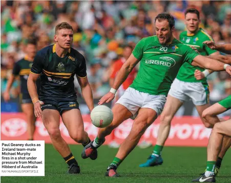  ?? RAY McMANUS/SPORTSFILE ?? Paul Geaney ducks as Ireland team-mate Michael Murphy fires in a shot under pressure from Michael Hibberd of Australia