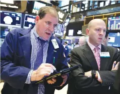  ?? — AP ?? NEW YORK: Jonathan Niles (left) and Jay Woods work on the floor of the New York Stock Exchange.