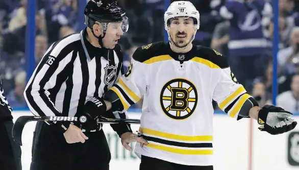  ?? CHRIS O’MEARA/THE ASSOCIATED PRESS ?? Boston Bruins winger Brad Marchand is escorted off the ice after taking a penalty in the first period of Game 5 Sunday against Tampa.