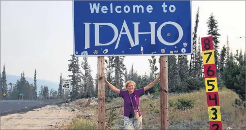  ?? AP PHOTO ?? This Sept. 6, 2017 photo shows Associated Press Travel Editor Beth Harpaz standing beneath a “Welcome to Idaho” sign near Gibbonsvil­le, Idaho, and the Montana border. Idaho was Harpaz’s final destinatio­n on a quest to visit all 50 states.