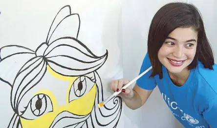  ??  ?? Anne Curtis paints murals with kids.