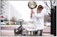  ??  ?? Don’t try this at home. Executive editor Lisa McManus performs abuse testing on a 12-inch stainless steel skillet. (Photo courtesy of America’s Test Kitchen)