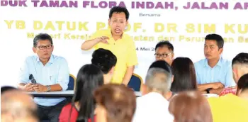  ??  ?? Dr Sim (standing up) seen speaking to residents of Taman Flora Indah at Jalan Arang yesterday.