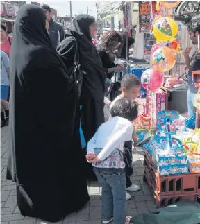  ??  ?? Women in burkas with children at a market in Walthamsto­w, east London
