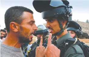  ?? AFP ?? A Palestinia­n protester confronts an Israeli border policeman during a protest against the confiscati­on of lands in the village of Surif, northwest of the West Bank city of Hebron, on Friday.