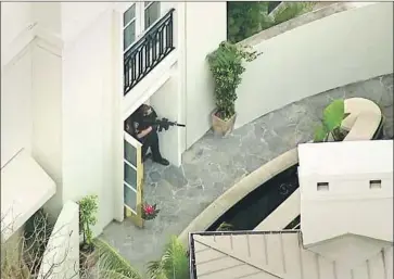  ?? KTLA-TV ?? AN OFFICER aims a rifle from a doorway at the Peninsula Beverly Hills after a “swatting” call Thursday.