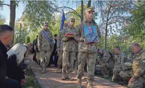  ?? EFREM LUKATSKY/AP ?? Ukrainian troops carry a portrait and personal effects at the funeral for Lt. Col. Vitali Baranov Wednesday in Katiuzhank­a, Ukraine.