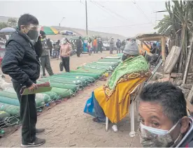  ??  ?? ABOVE Relatives caring for Covid-19 patients wait for empty oxygen cylinders to be refilled on the outskirts of Lima.