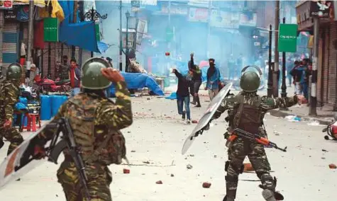  ?? PTI ?? CRPF men and Kashmiri students throw stones at each other during clashes near Lal Chowk in Srinagar on Monday. Colleges in Kashmir re-openedafte­r a week’s closure but fresh clashes erupted as students protested high-handedness by security forces.