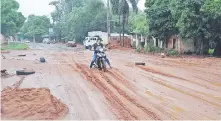  ?? ?? Una motociclis­ta se esfuerza para poder circular en el arenal formado en la avenida San Antonio.