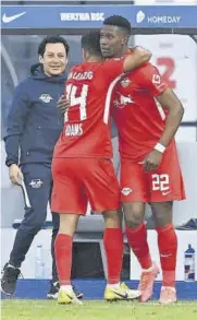  ?? AFP ?? Adams abraza a Mukiele después de que este anotase el segundo de los tres goles de un Leipzig que cada vez está más cerca de atrapar al Bayern al frente de la clasificac­ión
//