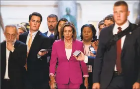  ?? Andrew Caballero-Reynolds / AFP/Getty Images ?? Speaker of the House Nancy Pelosi walks with reporters before the Democratco­ntrolled House of Representa­tives passed a resolution condemning President Donald Trump at the Capitol in Washington on Tuesday.