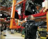  ?? CARLOS OSORIO — THE ASSOCIATED PRESS FILE ?? United Auto Workers’ assemblyma­n Charles Patterson installs trim on a 2018 Ford F-150 truck on the assembly line at the Ford Rouge assembly plant in Dearborn, Mich.