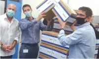  ?? ( Courtesy) ?? YUVAL LANDSCHAFT, head of the Health Ministry’s Medical Cannabis Unit ( left), Panaxia CEO Dadi Segal and Seach Medical Group CEO Yogev Sarid stand with the first commercial shipment of medical cannabis from Israel.