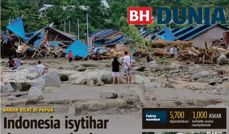  ??  ?? Penduduk meninjau kemusnahan rumah mereka selepas banjir kilat di Sentani, Papua, kelmarin.