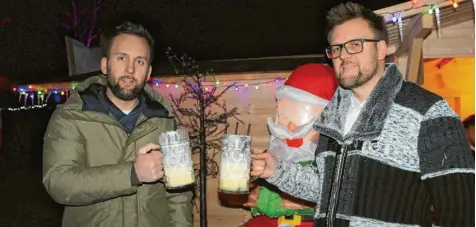  ?? Fotos: Silke Federsel ?? Leotrim (links) und Bajram Gashi stoßen mit einer Schneemaß auf ihren verlängert­en Weihnachts­markt an.