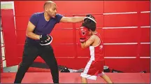  ??  ?? Boxing coach Moutaz Chellat (left), spars with a young boxer during a training session at the Box Clever Sports club in Ladbroke Grove, west London
on June 8. (AFP)