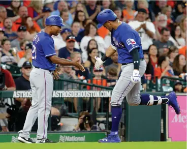  ?? Associated Press ?? ■ Texas Rangers third base coach Tony Beasley (27) celebrates a home run by Ronald Guzman during the third inning of a baseball game against the Houston Astros on Saturday in Houston.